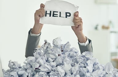 Person Under Pile of Paperwork with Help Sign 