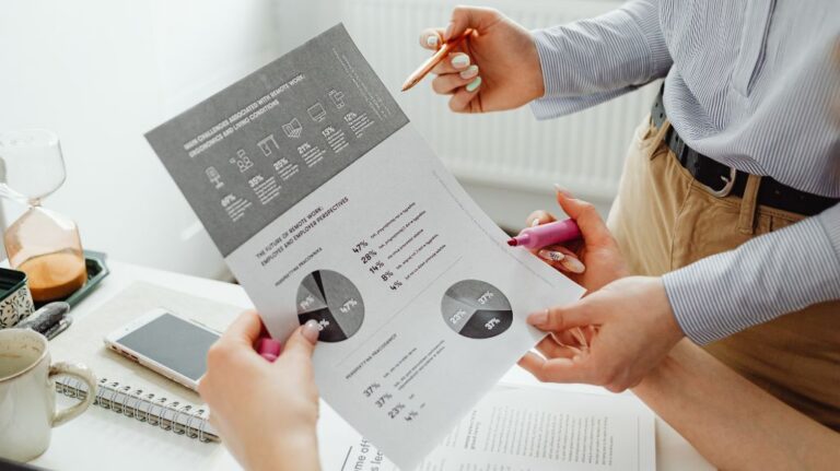 People Looking at a Printout of Stats and Graphs