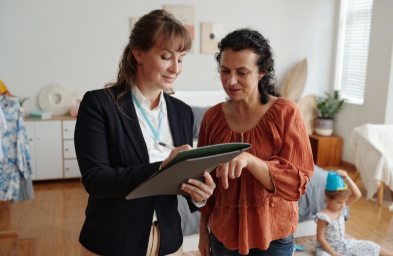 Woman Social Worker Helping a Mom with Documents