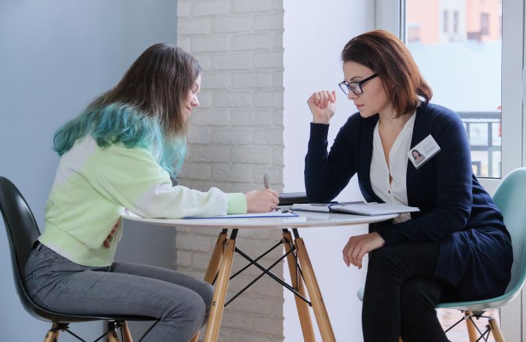 Social Worker and Woman Doing Paperwork at a Table