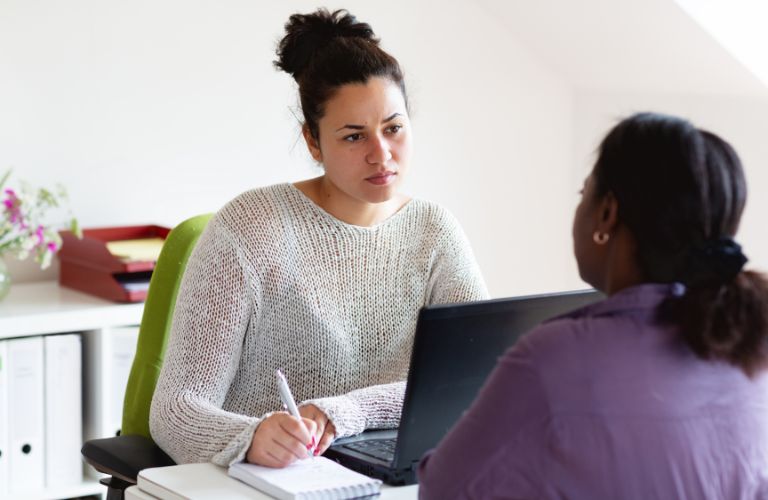 Woman Social Worker Facing and Talking to Young Girl