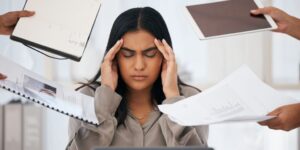 Many People Handing Paperwork to Overwhelmed Social Worker