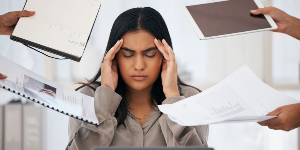 Many People Handing Paperwork to Overwhelmed Social Worker