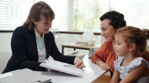 Female Social Worker Looking at Documents with Woman and Child