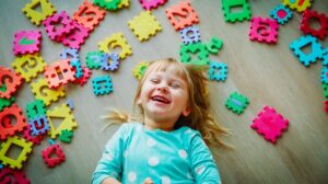 Little Girl Lying on a Floor with Puzzle Pieces