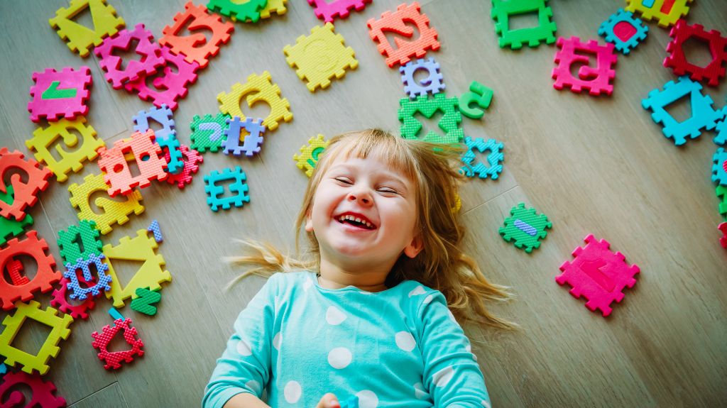 Little Girl Lying on a Floor with Puzzle Pieces